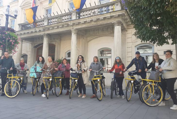 Ľudia s bicyklami stoja v rade vedľa seba