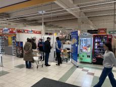 People in supermarket in front of the Populair info point